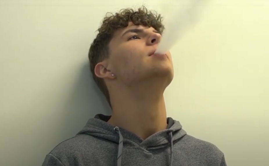 a male student vapes in the school bathroom