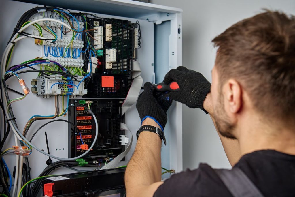 A technician works to install integrated automation systems for a modern building.